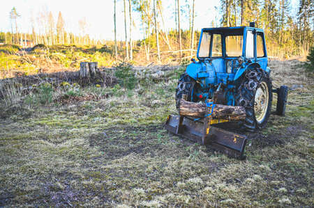 old blue tractor with plow waiting for snowの写真素材