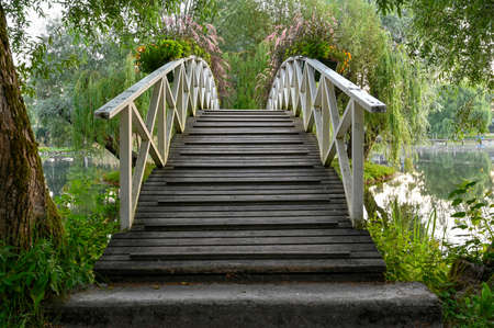 wooden bridge over water in beautiful parkの写真素材