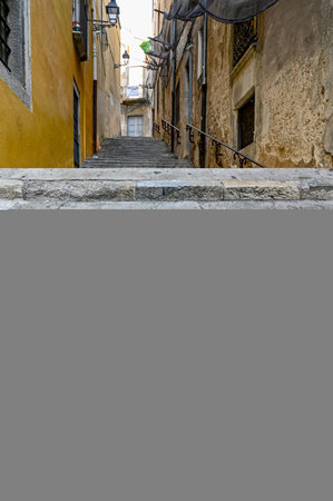 narrow stone stairs with railing between stone wallsの写真素材