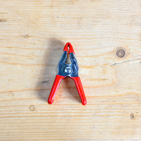 tiny little clamp lying on wooden bench