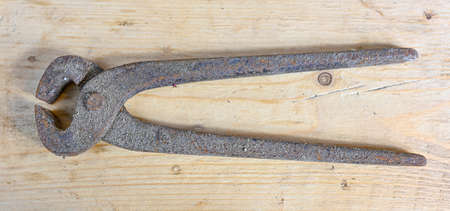 old dirty rusty vintage pincer on wooden workbenchの写真素材
