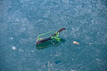 kids toy snowracer left on lakes iceの写真素材