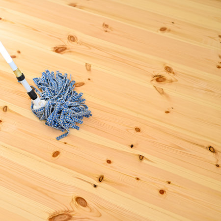 person mops new wooden floor with lots of twigs