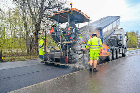 road worker laying asphalt on road in Swedenのeditorial素材