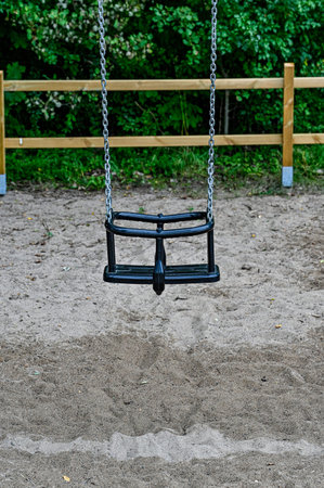 swing in chains at playingground with fence
