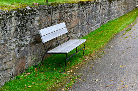 stonewall and bench near a walkingpath at cemeteryの写真素材