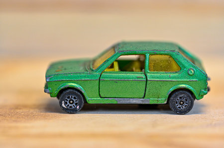 closeup on a green toy car on wooden bench