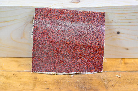 a bit of red rough sandpaper on wooden bench
