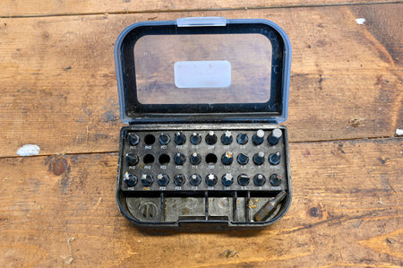 Box of hex bits standing on wooden bench in workshop