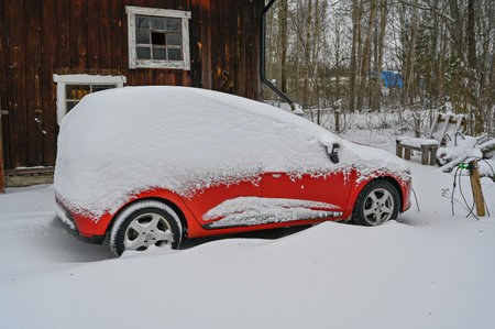 red car covered in snow Sweden january 6 2023の写真素材