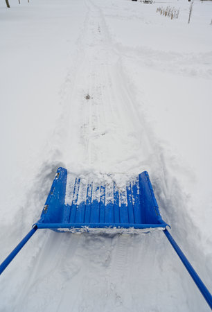 big blue plastic shovel taking care of snow in Swedenの写真素材