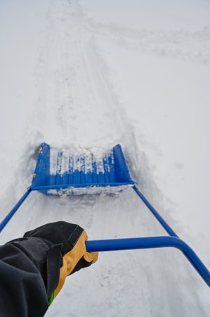 big blue plastic shovel taking care of snow in Swedenの写真素材