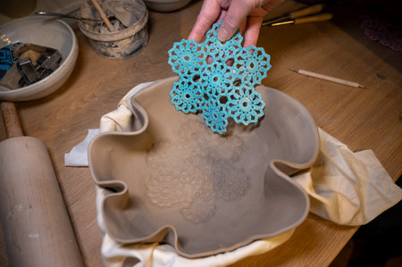 Hands making things with rolled clay in studio
