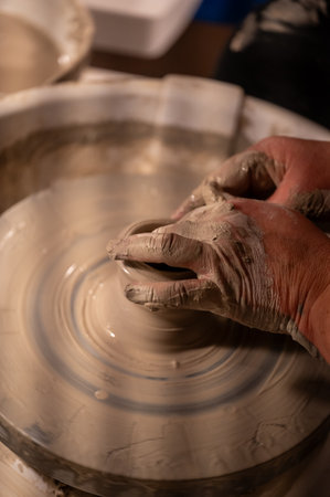 Potters wheel with hands forming clay to artの写真素材