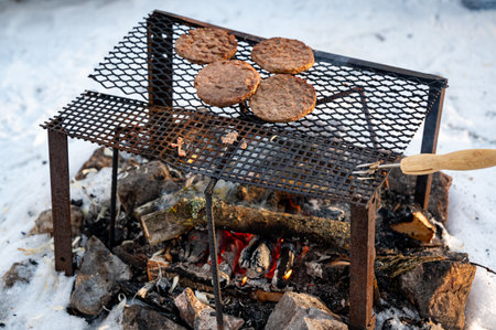 Four hamburgers over open fire outside in winterの写真素材