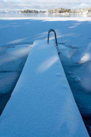 Jetty covered in snow a cold winter dayの写真素材