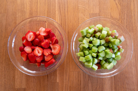 Two glass bowls with strawberries and rhubarbの写真素材