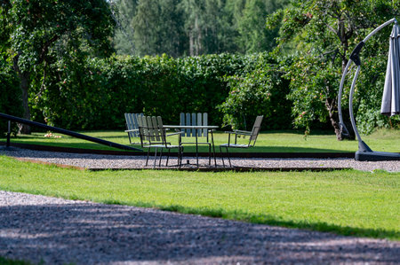 Garden furniture standing on gravel in beautiful gardenの写真素材