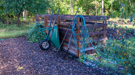 Home made compost wheelbarrow and garden hoseの写真素材