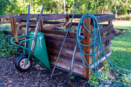 Home made compost wheelbarrow and garden hoseの写真素材