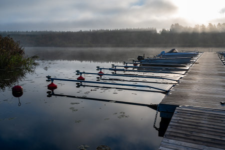 Motor boats at wooden jetty early morning Motala Swedenの写真素材