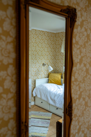 Mirror in guest room with yellow retro wall paperの写真素材