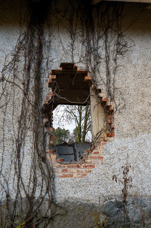 Old house with big hole in brick wallの写真素材