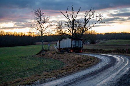 Truck with trailer on narrow wet and soft gravel roadの写真素材