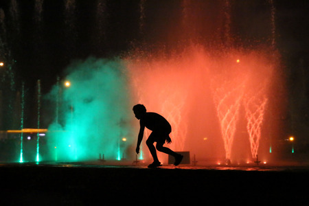 A young boy frolicking on the fountain in Warsawの写真素材