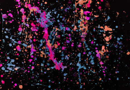 Speckled paint of different colors on a black backgroundの写真素材