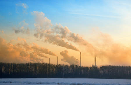 Steam from the factory at sunrise in winter.の写真素材