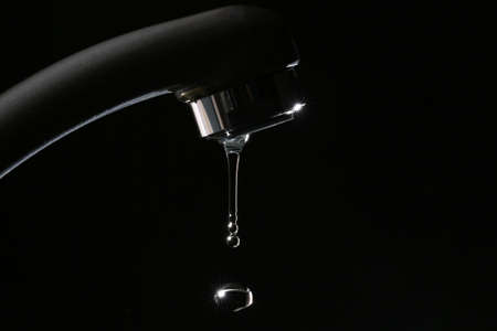 Failure of pure tap water on a black backgroundの写真素材