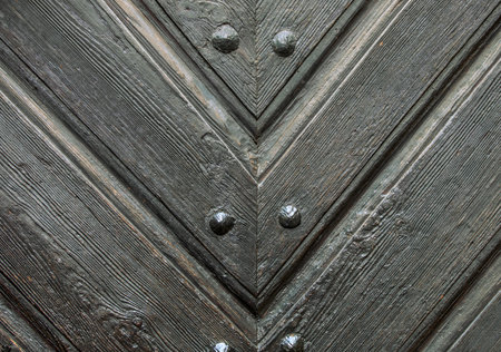 Old wooden door with rivets and nails, closeup of photoの写真素材