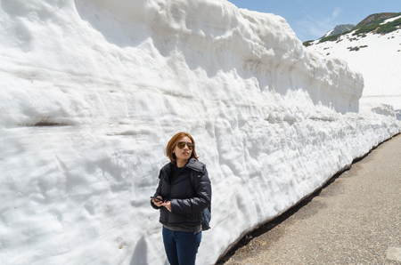 Female traveler and snow wall at japan alps tateyama kurobe alpine routeの写真素材