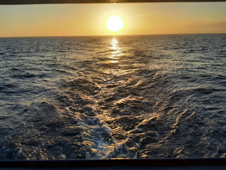 Cruise ship's Wake On The Water Of Ocean on sunsetの写真素材