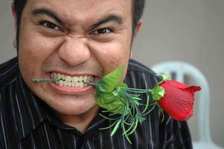 man biting a roseの写真素材