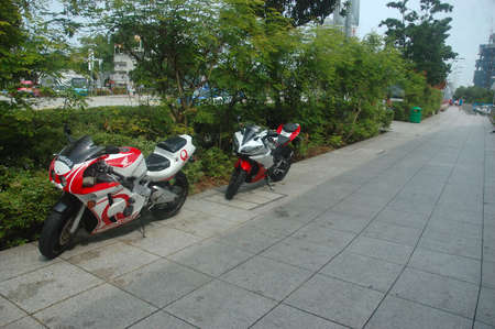 Singapore, Singapore - January 18, 2014: Honda motorcycle parked beside garden.のeditorial素材