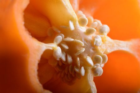 Macro shot of sliced fresh orange bell pepper with seeds.