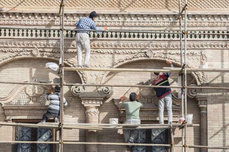 Tehran, IRAN - March 8, 2018 workers repairing ancient building in downtown beside urban street.