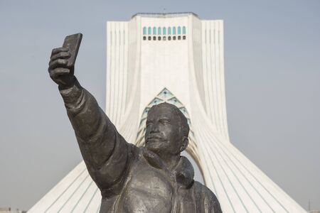 TEHRAN, IRAN - 7 May  2018 Taking a selfi with phone sculpture, Azadi tower at background  is a architecture landmark of Tehranのeditorial素材