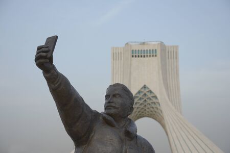 TEHRAN, IRAN - 7 May  2018 Taking a selfie with phone sculpture, Azadi tower at background  is a architectural landmark of Tehranのeditorial素材