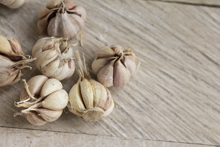 Garlic cloves on a vintage wooden board background, organic and healthy food.の写真素材