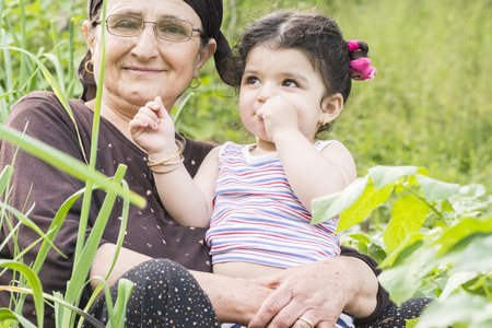 Close-up portrait of Senor Grandmother with her little grandchild at garden enjoying together