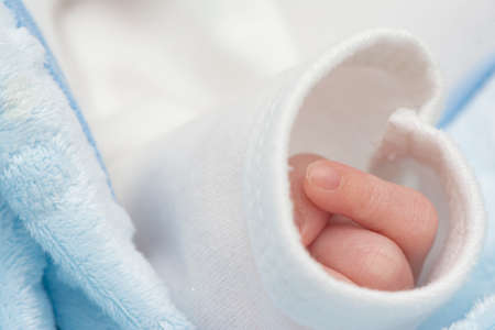 Newborn baby hand in sleeve peacefully sleept,  macro shot
