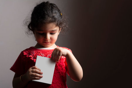 Little girl opening a small box in front of body, editable mock-up series template ready for your design, box faces selection path included.の写真素材