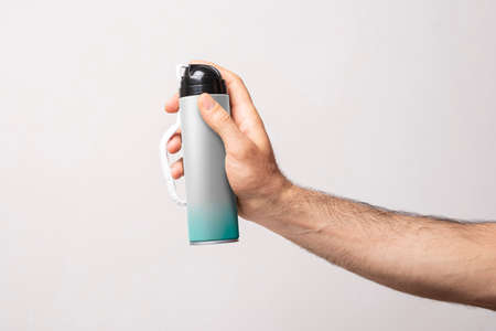 Male arm holding a bottle of shaving foam in front of gray background, editable mock-up series template ready for your design, bottle label selection  .の写真素材