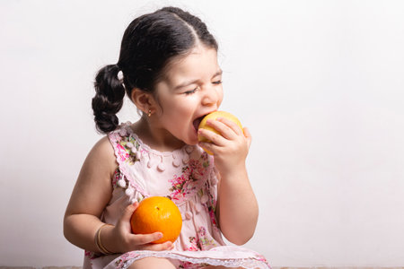 Portrait of an adorable little girl eating an apple. Children fruit and vegetables nutrition conceptの写真素材