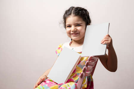 Little girl holding two story books with blank covers, editable mock-up series. books cover selection path included.の写真素材