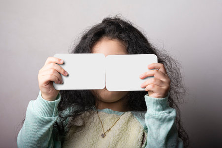 Little girl portrait holding two flash card in front of face, preschooler educational material learning objects. flash cards selection path included.の写真素材