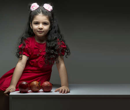 Little girl with three pomegranates in front of her. happy yalda Iranian celebration themeの写真素材